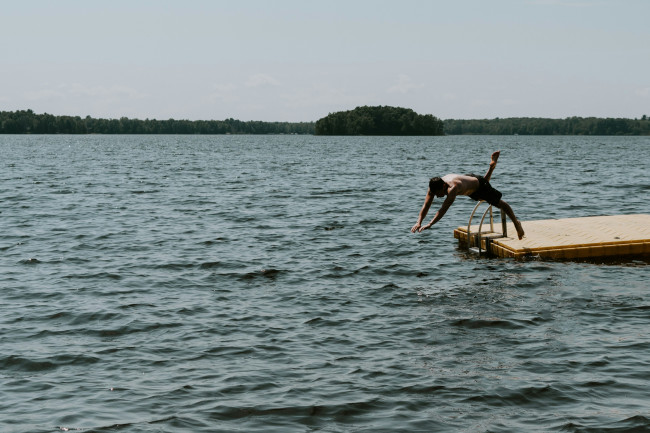 mann springt kopfüber in einen see